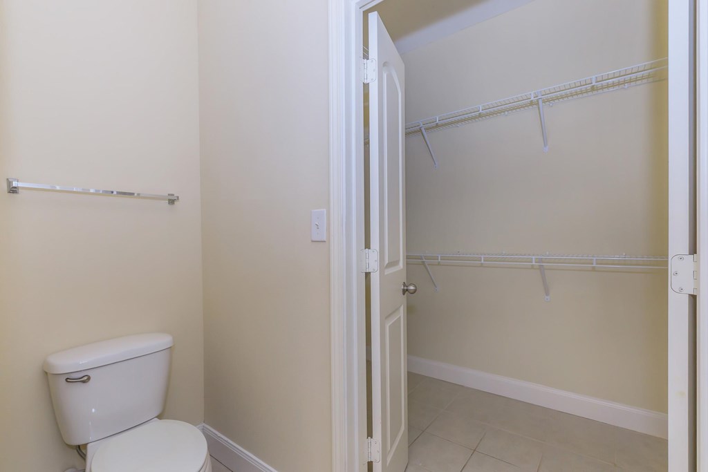 A white toilet sits next to a white door in a bathroom.