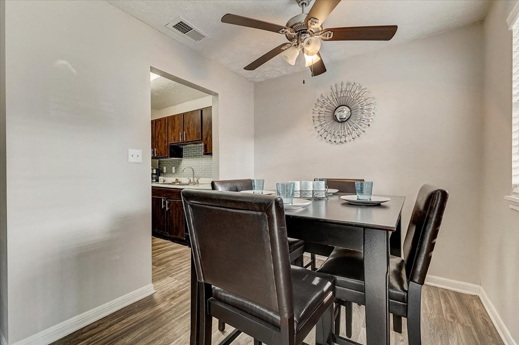 a dining room table with chairs and a ceiling fan