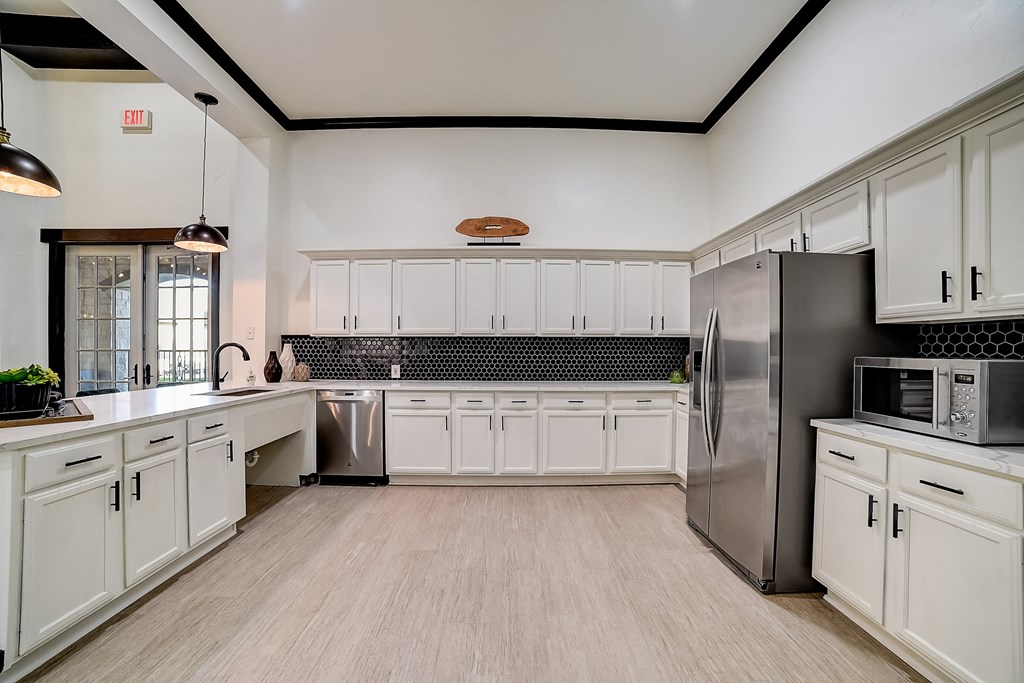 a large kitchen with white cabinets and stainless steel appliances