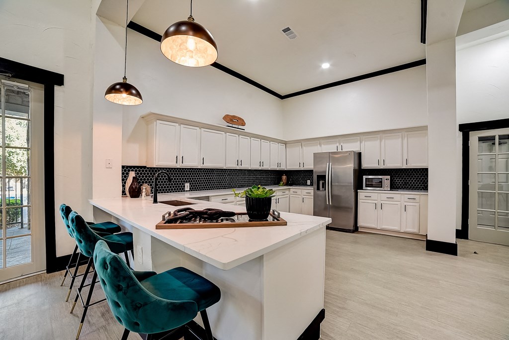 a kitchen with a large island and blue chairs