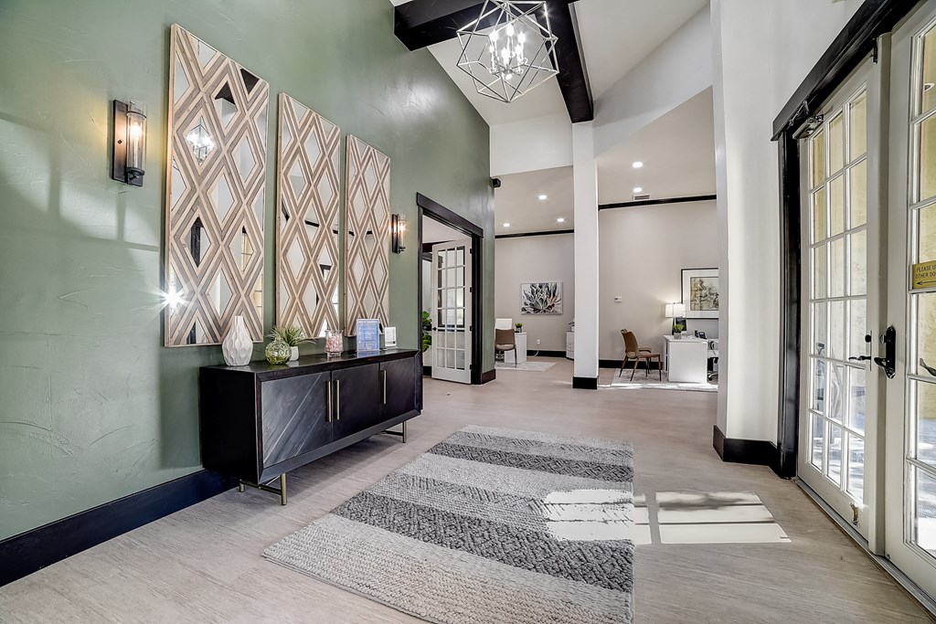 the lobby of a house with glass doors and a reception area with rugs