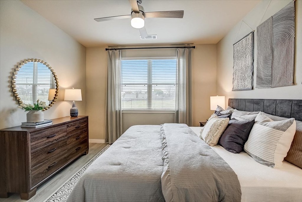 a bedroom with a large bed and a ceiling fan