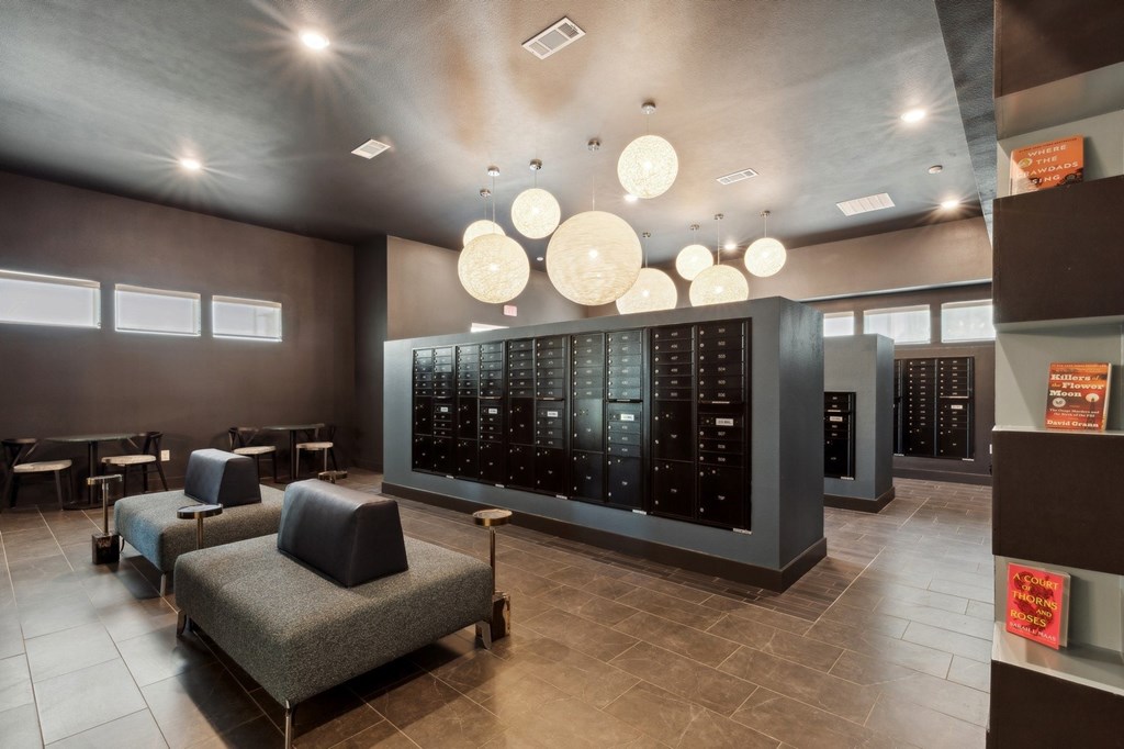 A modern waiting room with a row of chairs and a large screen on the wall.