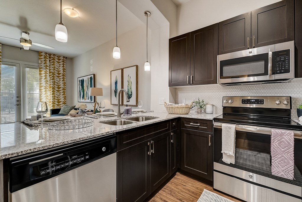 an apartment kitchen with stainless steel appliances and black and white cabinets