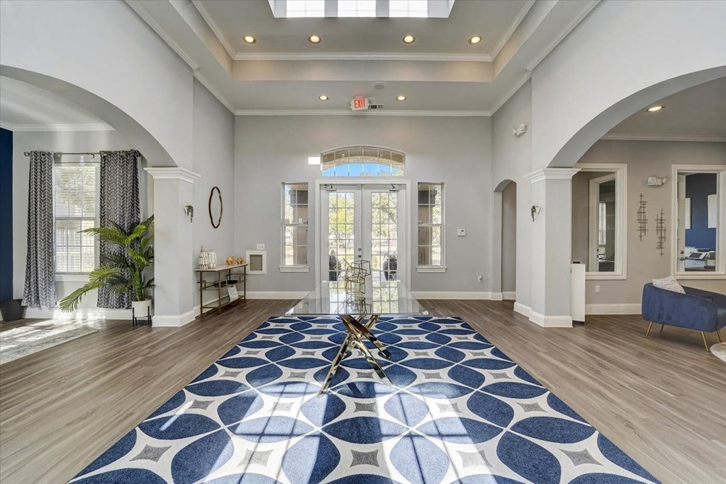 a large living room with a blue rug on the floor