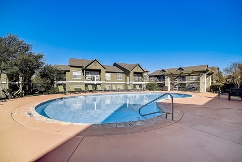 La Mirage in San Antonio resort-style pool with lounge chairs and nearby pergola.
