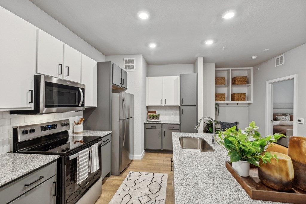 A modern kitchen with a black stove top oven and a black microwave.