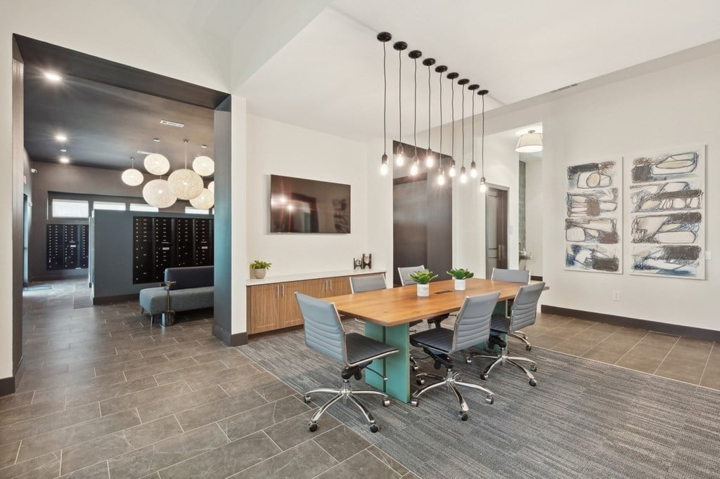 A modern office space with a long table and chairs.