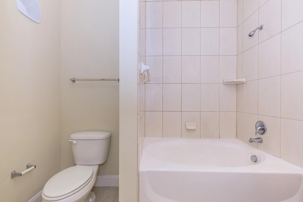 A white toilet and bathtub in a bathroom.