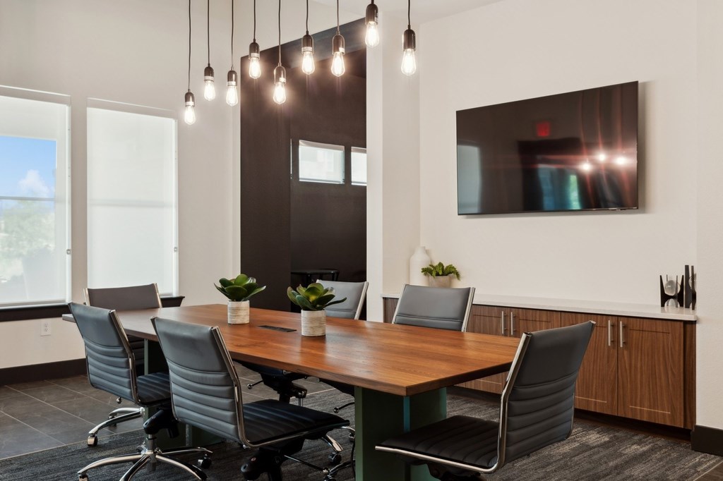 A conference room with a long table and chairs.