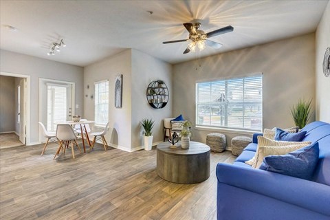 a living room with a blue couch and a ceiling fan