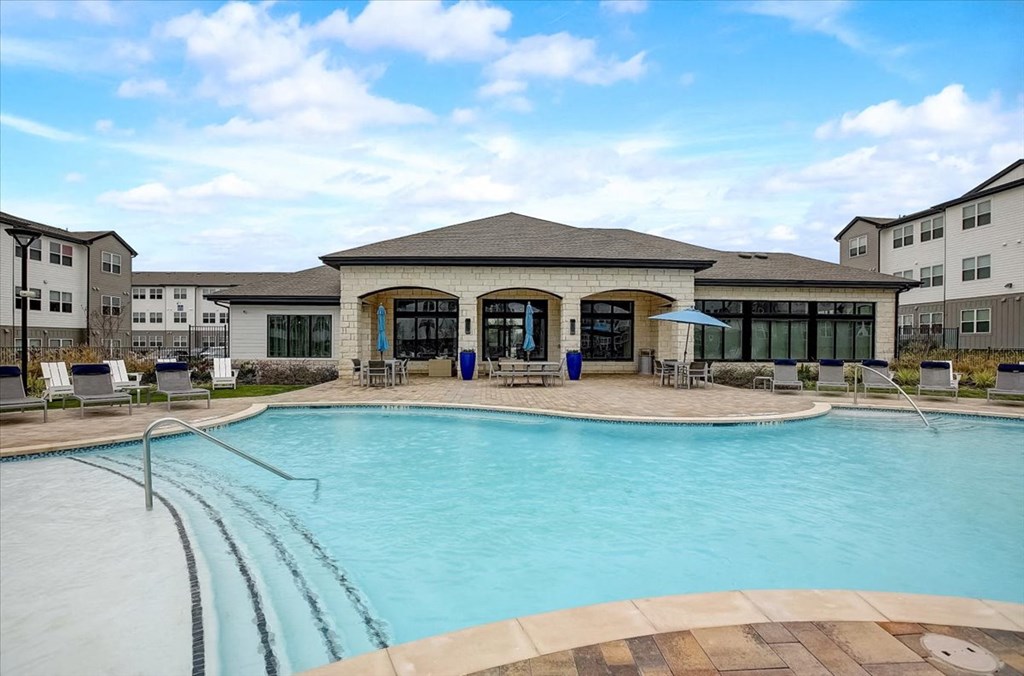 a large swimming pool in front of an apartment building