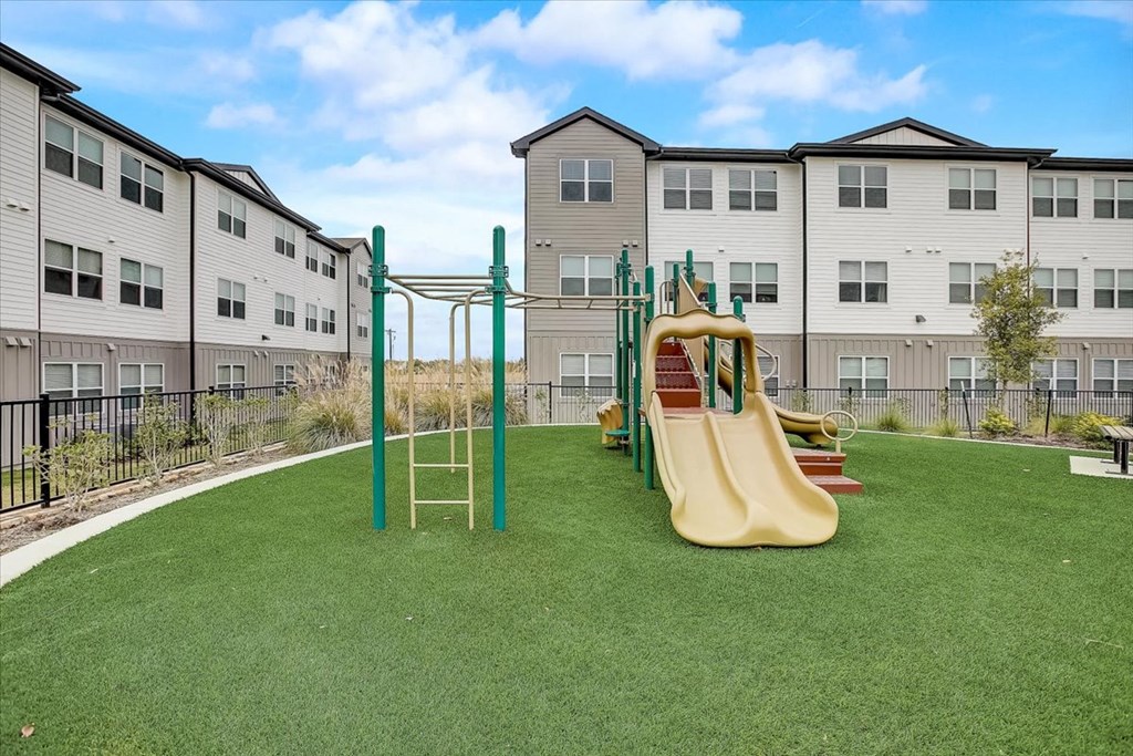 a playground with a slide in the middle of an apartment complex