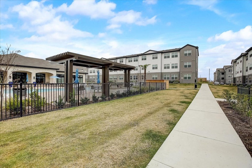 the yards are fenced in with grass and a sidewalk