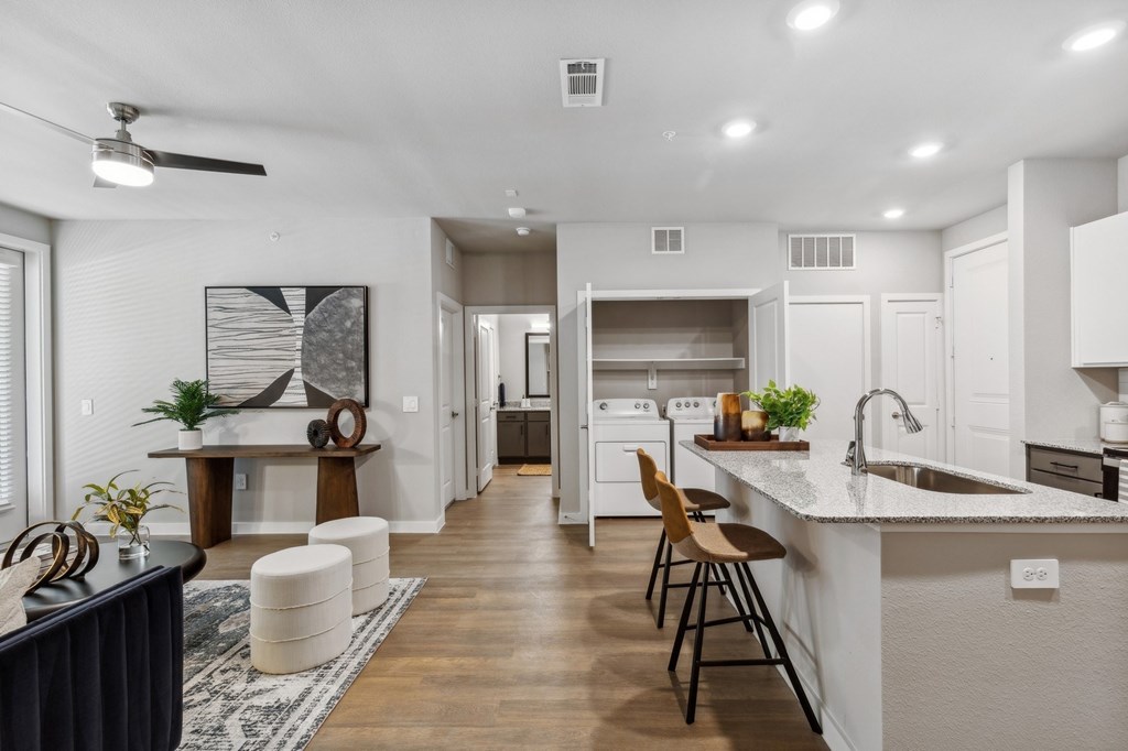 A modern kitchen with a bar area and a dining table.