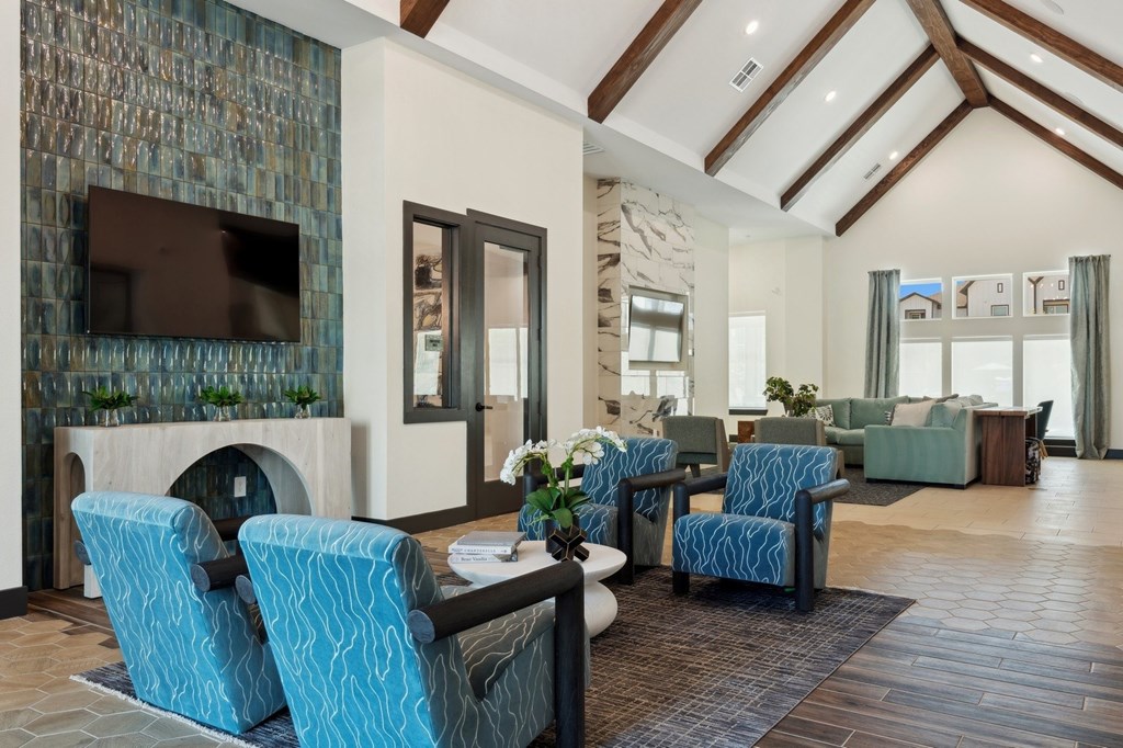 A living room with blue chairs and a television.