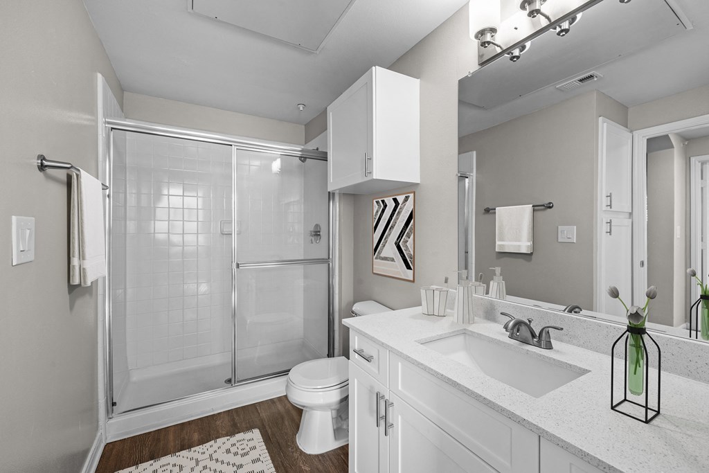 a white bathroom with a shower sink and toilet