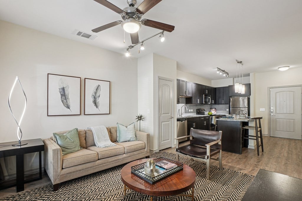 A living room with a couch, coffee table, and a ceiling fan.