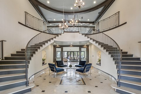 A large foyer with a staircase and a chandelier.