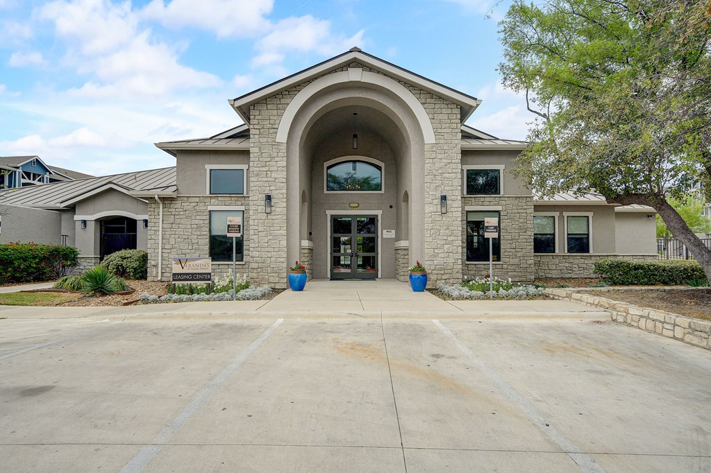 the exterior of a building with an archway and a driveway