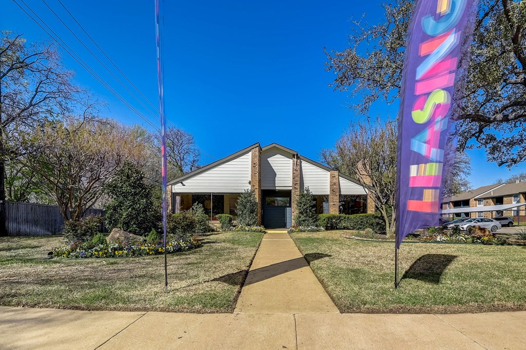 the front of a building with a purple and pink flag