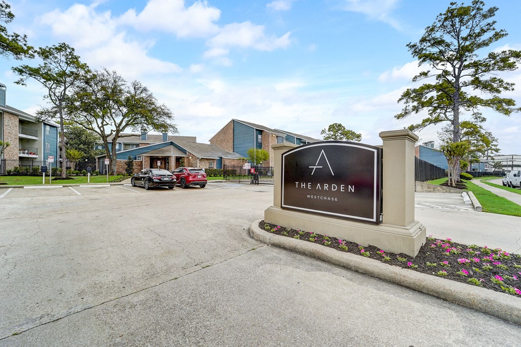 the arden apartments entrance sign with parking lot and buildings