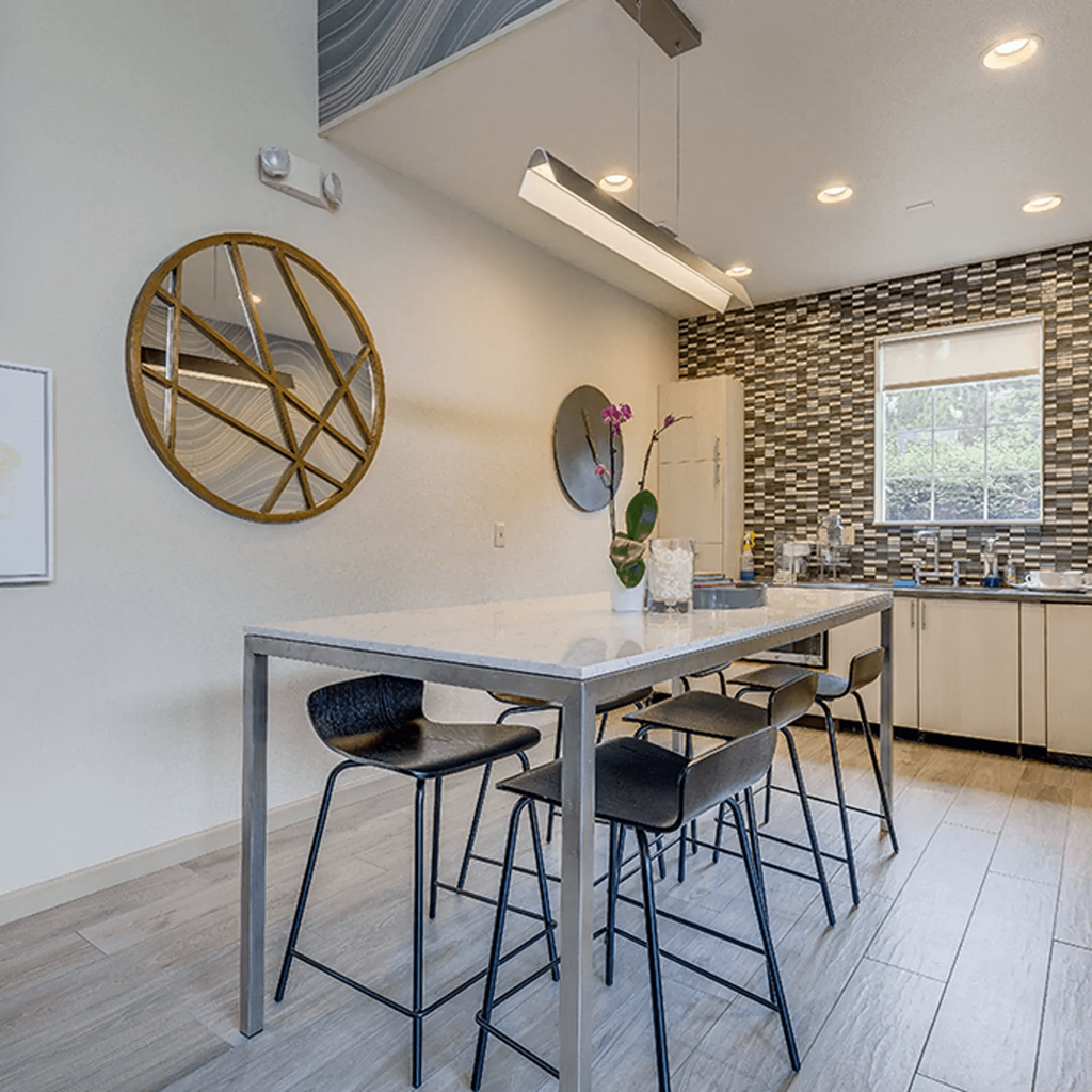 a kitchen with a long table with four stools