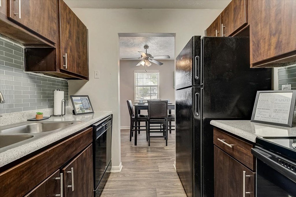 a kitchen with a black refrigerator and a table with chairs