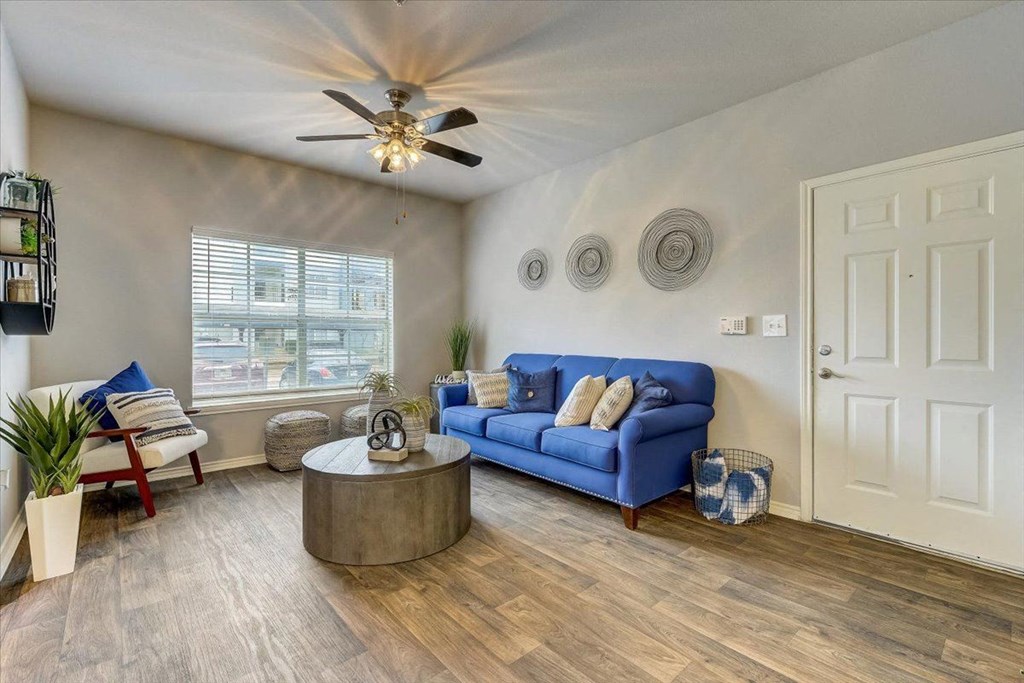 a living room with a blue couch and a ceiling fan