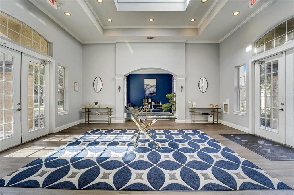 a living room with a blue rug and white doors