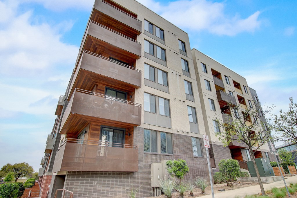 an apartment building with two balconies and a blue sky