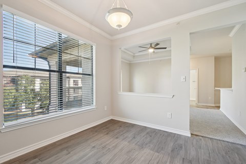 A room with a ceiling fan and a window with blinds.