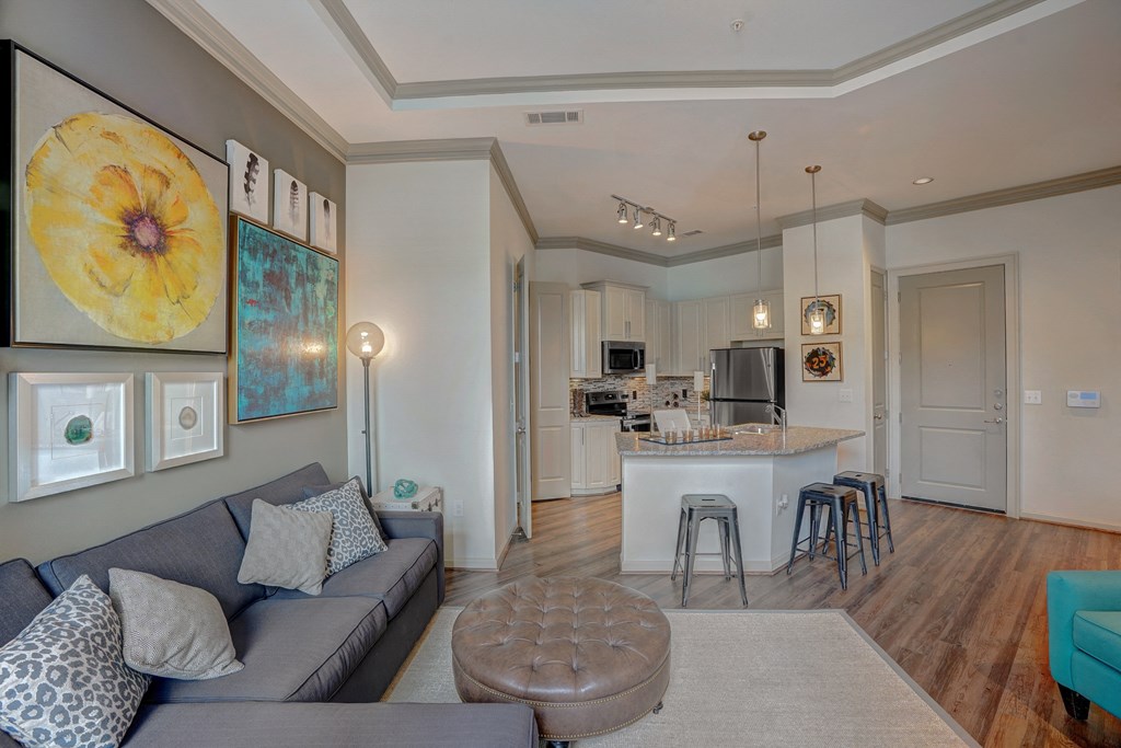 a living room with a couch and a kitchen with a bar