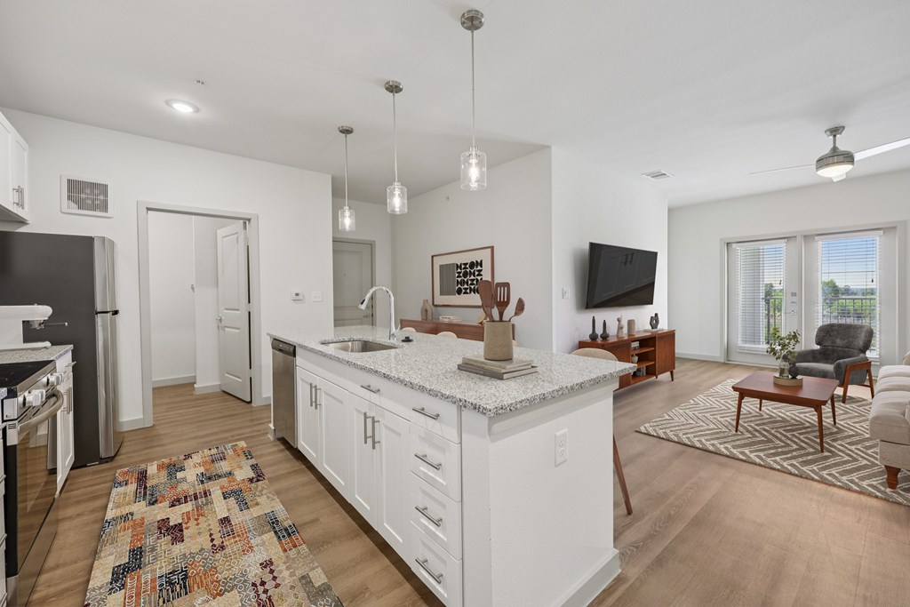 A kitchen with white cabinets and a granite countertop.