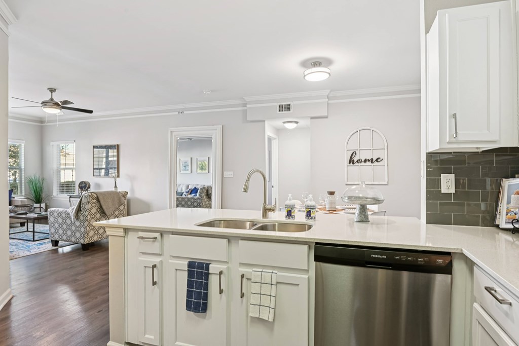 A kitchen with a stainless steel dishwasher and a white countertop.
