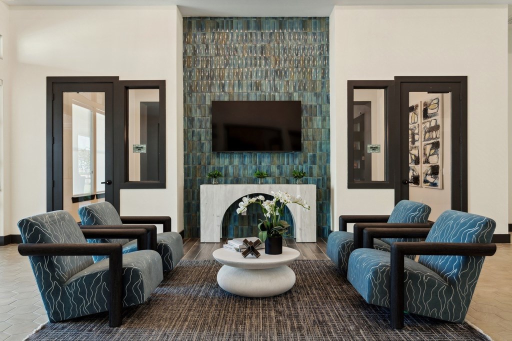 A living room with a fireplace and blue chairs.