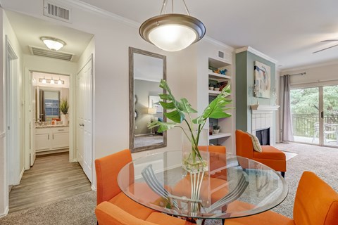 a dining room with orange chairs and a glass table