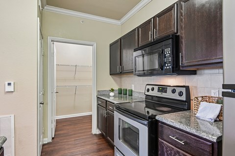 A kitchen with a black microwave above the stove.