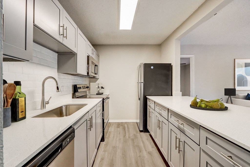 a kitchen with white cabinets and stainless steel appliances