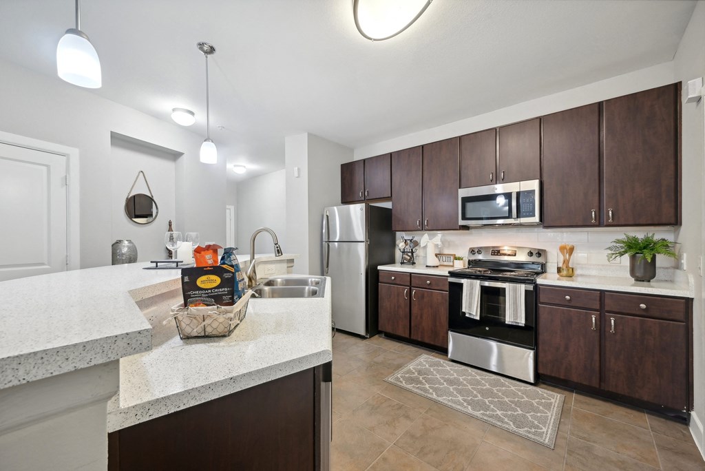 A kitchen with brown cabinets and a white counter.