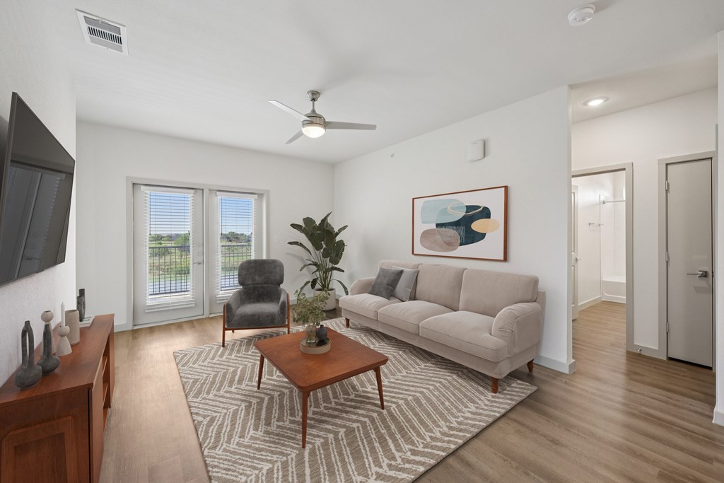 A living room with a couch, chair, and a painting on the wall.