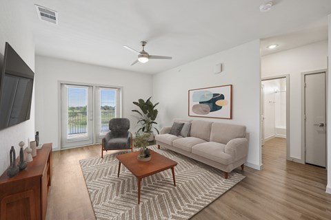 A living room with a couch, chair, and a painting on the wall.