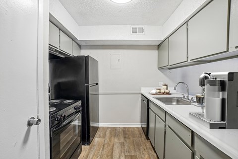 A kitchen with a black refrigerator and stove.