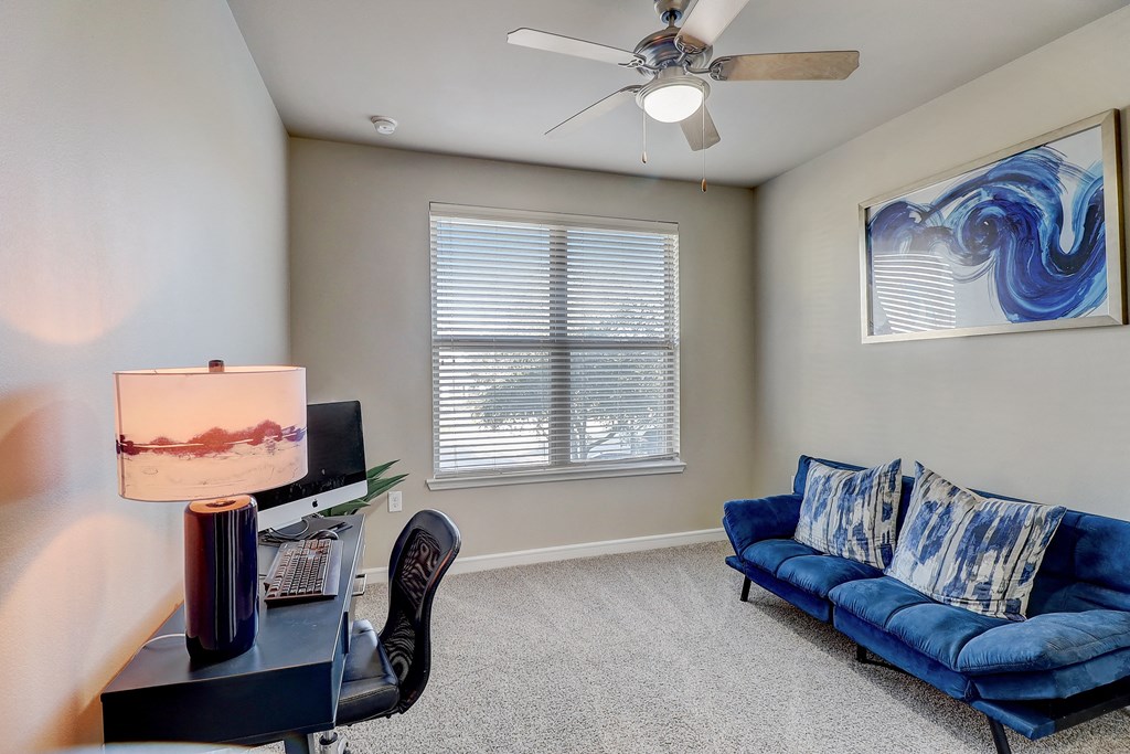 a living room with a blue couch and a ceiling fan