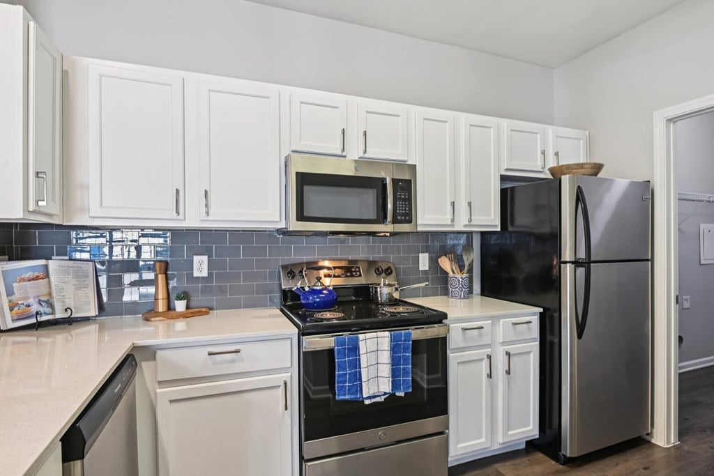 A kitchen with white cabinets and a black stove top.