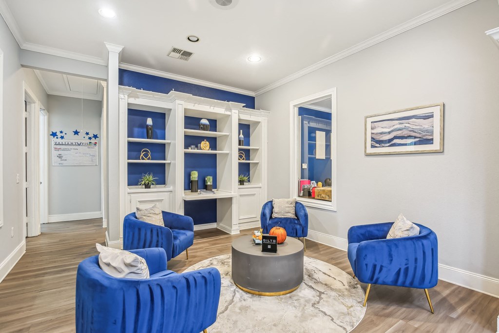A living room with blue chairs and a grey coffee table.