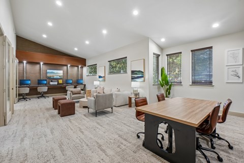 A modern office space with a variety of seating options and a long wooden table.