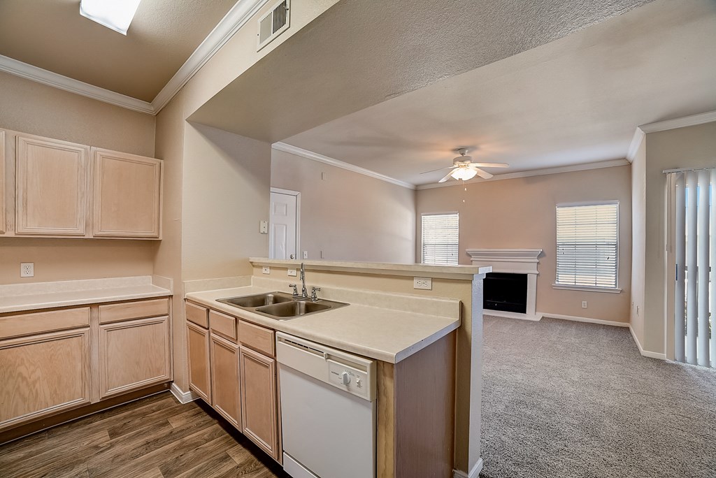 an empty kitchen with a sink and counter top