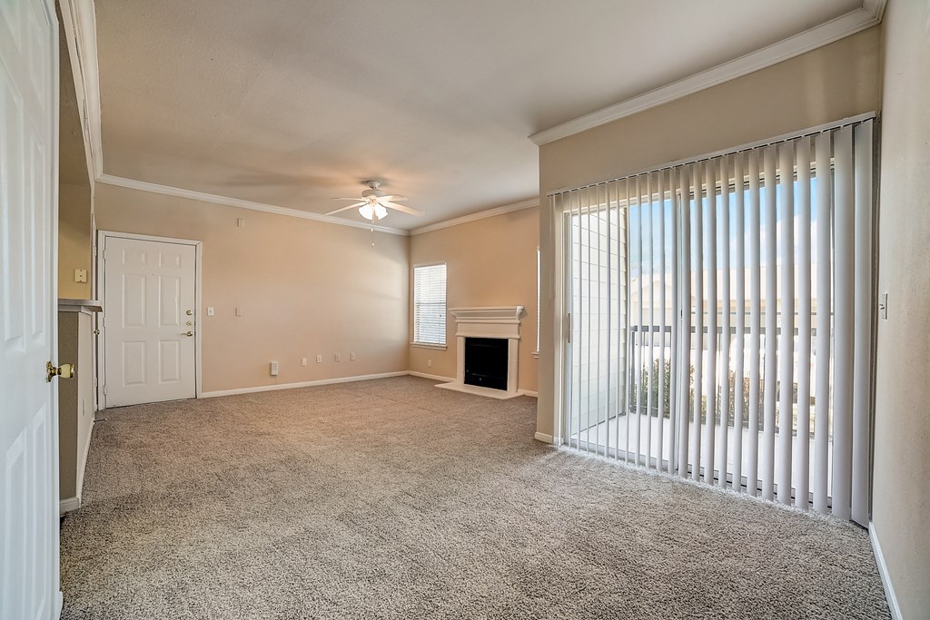 an empty living room with a fireplace and blinds on the window