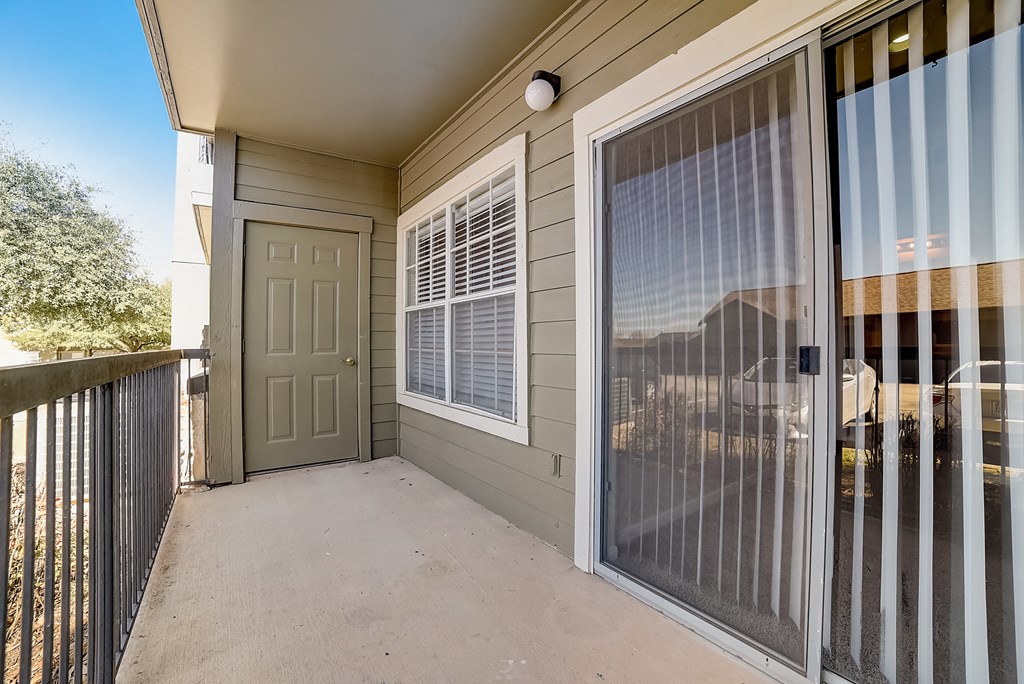 the front porch of a home with a white door and a patio